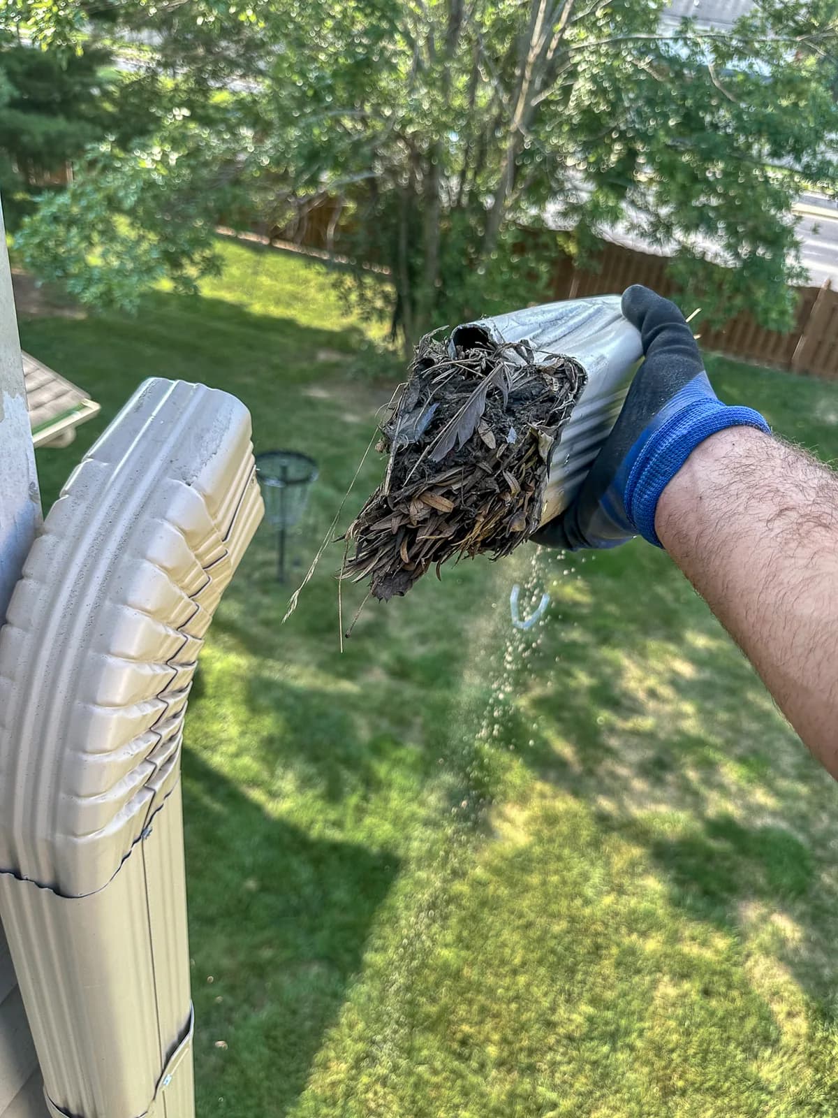 Clogged downspout disassembled showing debris buildup