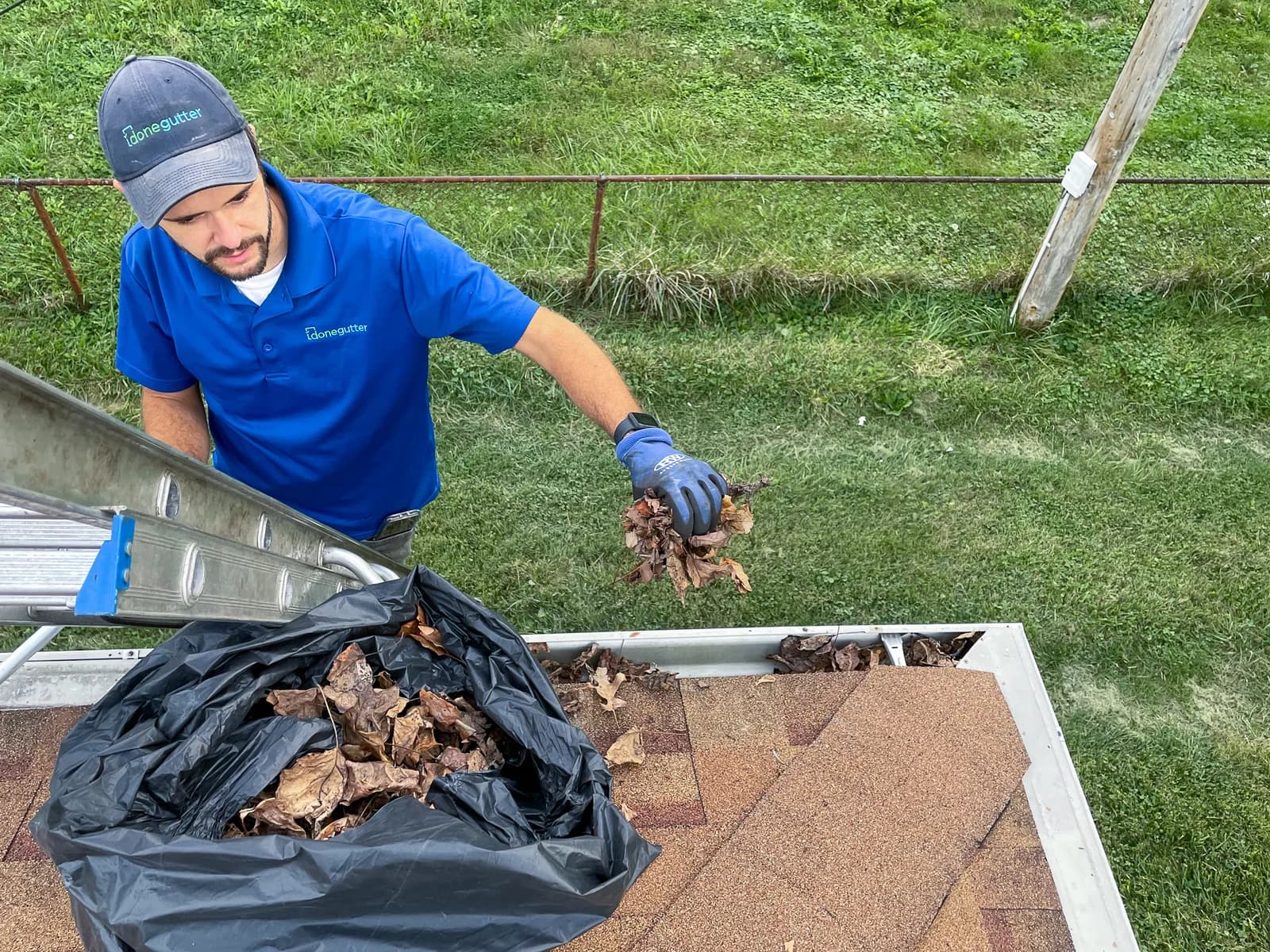Overhead view of worker cleaning gutter on residential home