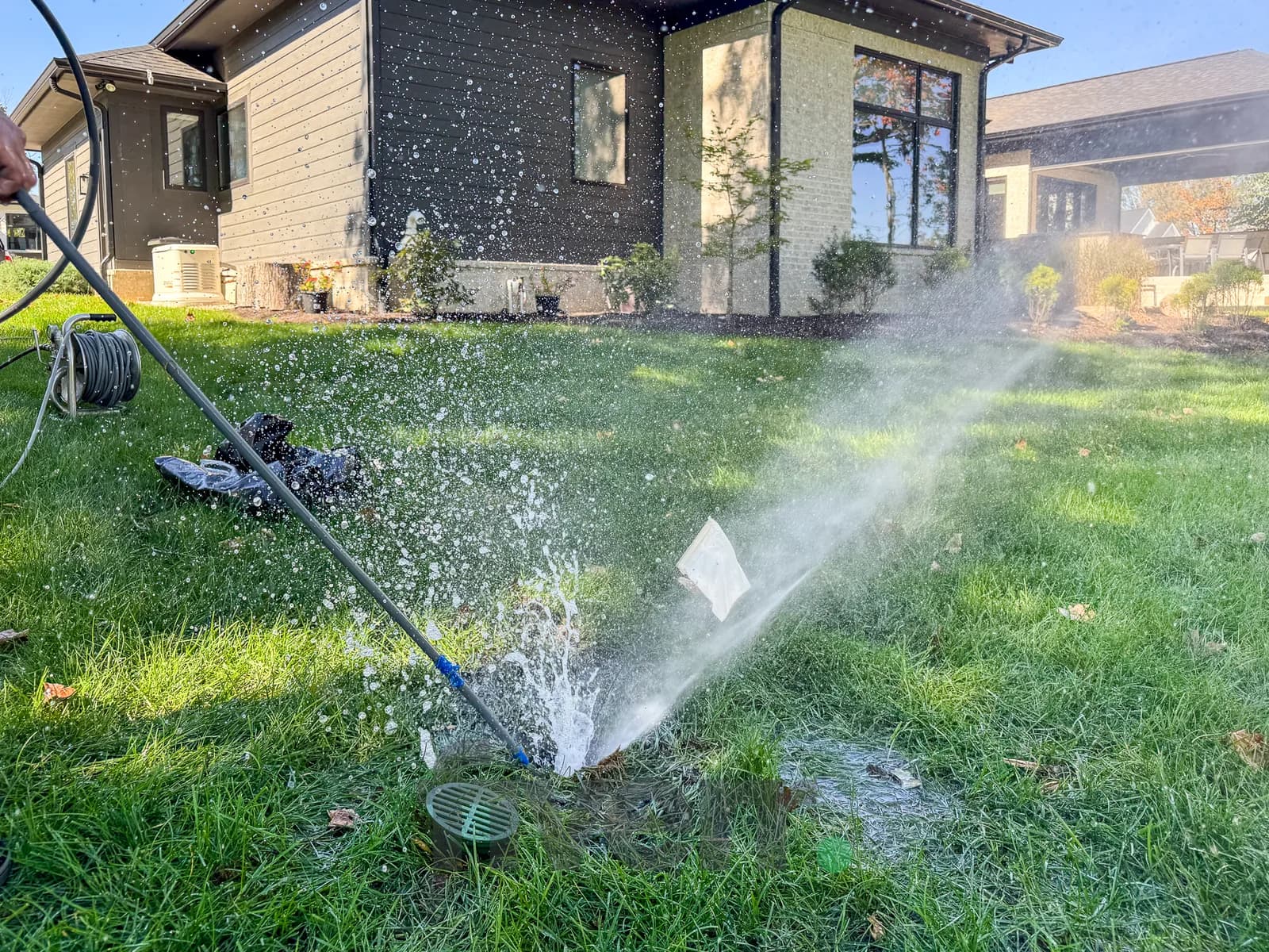 Water geyser erupting from yard drain during hydrojetting